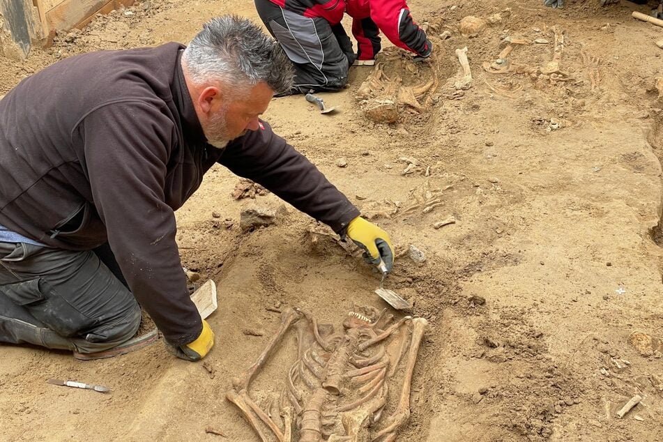Archäologen legen die Skelette in der Baugrube vorsichtig und Stück für Stück frei. Später sollen sie erneut bestattet werden.