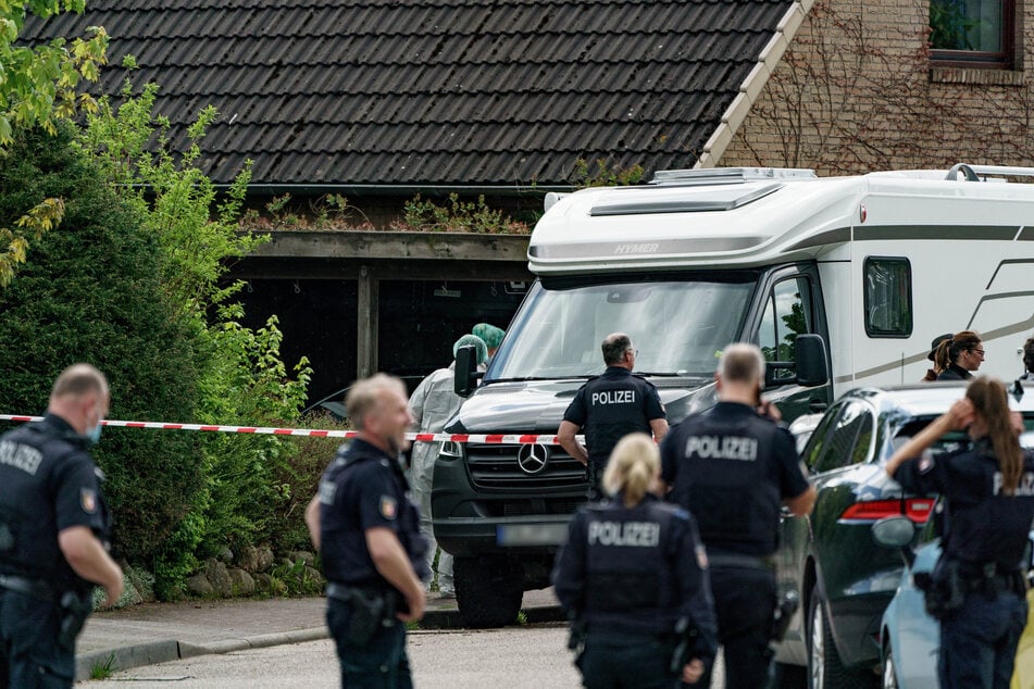 Polizisten untersuchen das Haus, in dem die beiden Toten gefunden wurden.