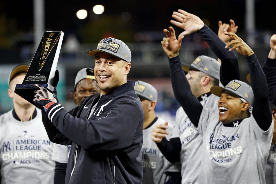 New York Yankees designated hitter Giancarlo Stanton celebrates with his teammates after winning the ALCS MVP award.