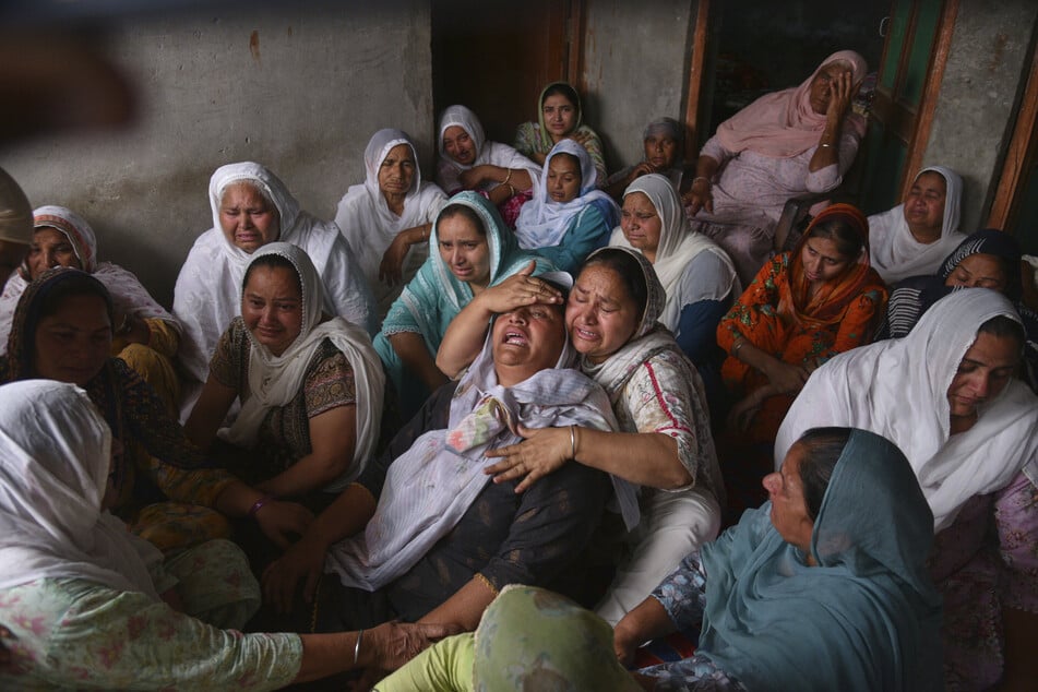 The wife of a man who died after consuming poisoned alcohol weeps in the Indian village of Majitha.