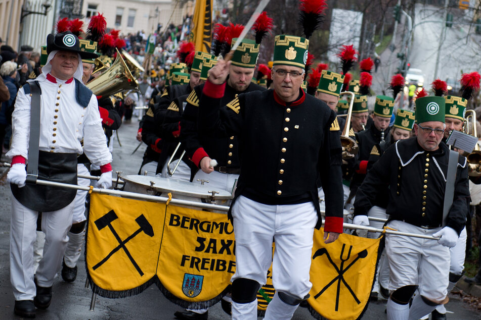 Teilnehmer der Bergparade in Freiberg gehen in historischer Bergarbeiterkleidung durch die Altstadt, das Fest findet auch dieses Jahr wieder statt - trotz Corona.