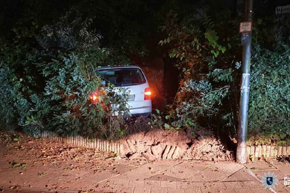 Der VW Touran steht in der Hecke.