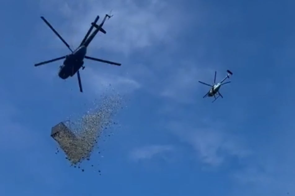 Der Moment, den niemand für möglich hielt: Ein Hubschrauber ließ Geld aus einem Container regnen.