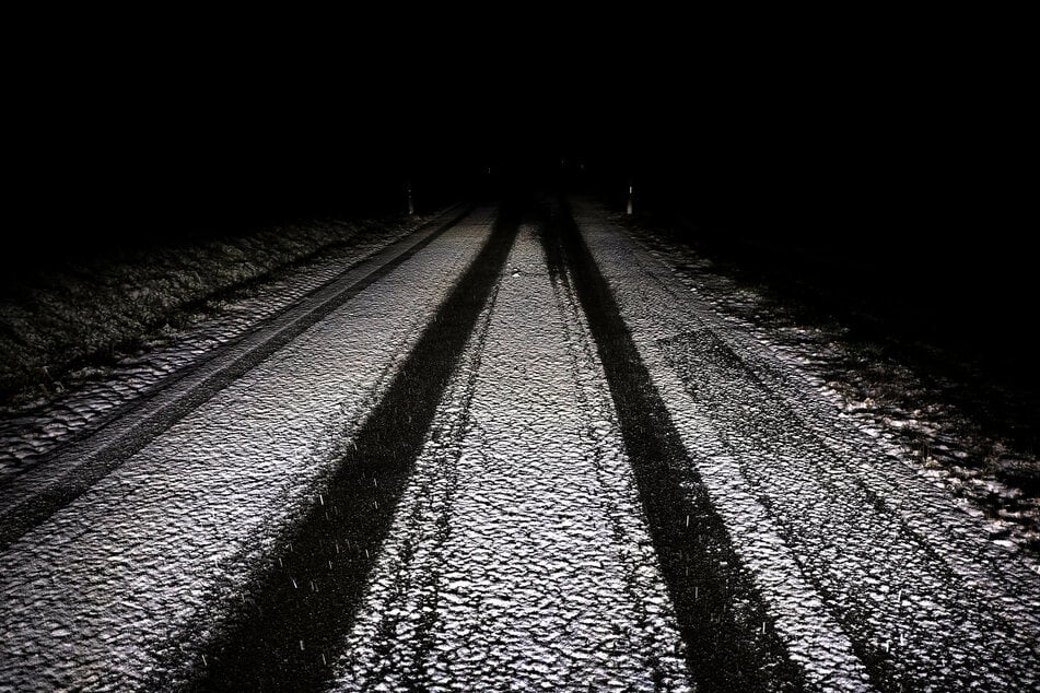 Eine mit Schnee überzogene Nebenstraße bei Kaufbeuren im Allgäu am Abend.