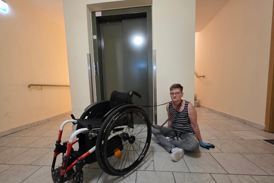 Heike Z. (55) sitzt vor dem kaputten Fahrstuhl.