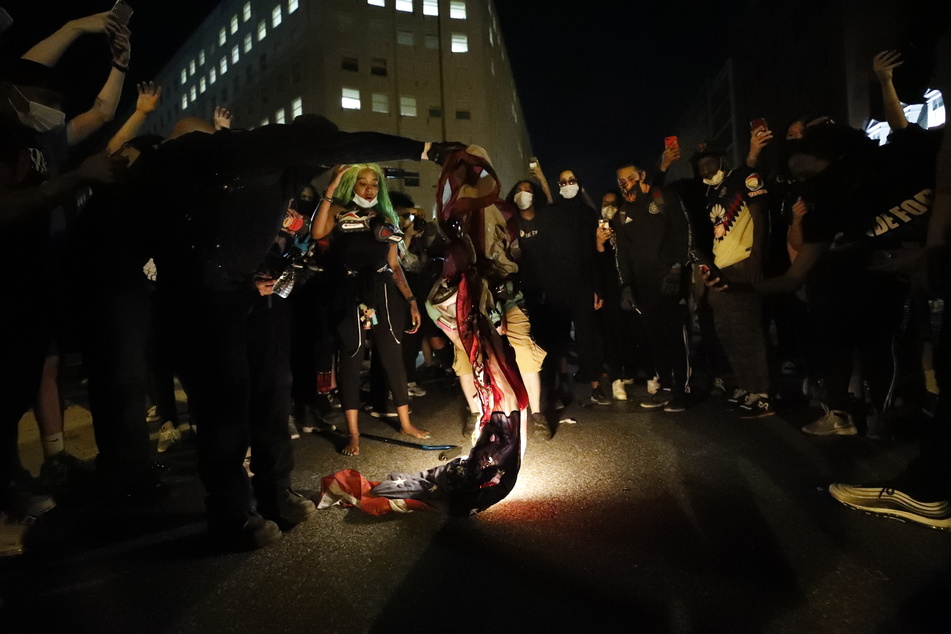 Demonstranten verbrennen während eines Protests in Washington eine amerikanische Flagge.