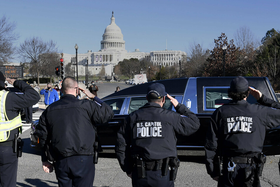 Capitol Hill police salute the passing of the funeral hearse for slain Officer Brian Sicknick, who died in the rioting.