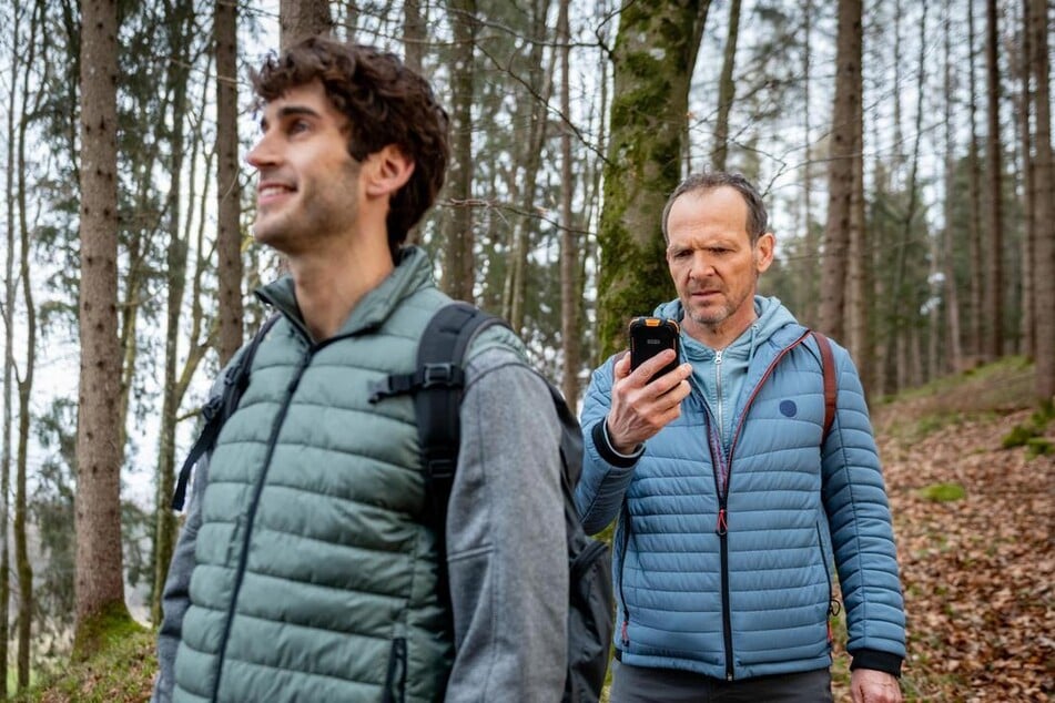 Markus (Timo Ben Schöfer, 57, r.) ist mit Noah (Christopher Jan Busse, 33) im Wald, als er eine beunruhigende Nachricht erhält.