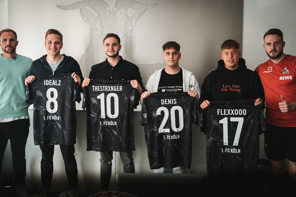 Das neue Team wird von Rafael Czichos (31, l.) und Jannes Horn (24, r.) begrüßt. Die Neuzugänge Lukas Schmandt (25, v.l.n.r.), Tim Katnawatos (22), Denis Müller (19) und Felix Günther (24) halten ihre neuen E-Sport-Trikots in den Händen.