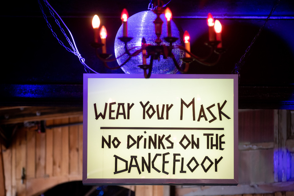 Ein Schild mit der Aufschrift «Wear your mask, no drinks on the dancefloor» (Maske tragen, keine Getränke auf der Tanzfläche) ist am Eingang zum Nachtclub Ritter Butzke in Berlin-Kreuzberg während eines Treffens von Vertretern der Berliner Club-, Kultur- und Veranstaltungsbranche mit Bundesgesundheitsminister Spahn zur Zukunft der Branche zu sehen.