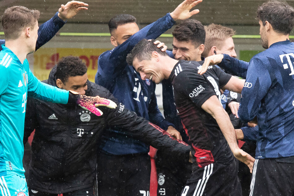 Seine Mitspieler und die Ersatzbank standen für Robert Lewandowski (4.v.l.) Spalier. Der Weltklasse-Stürmer traf in dieser Bundesliga-Saison zum 40. Mal und stellte damit den Uralt-Torrekord von Gerd Müller ein.