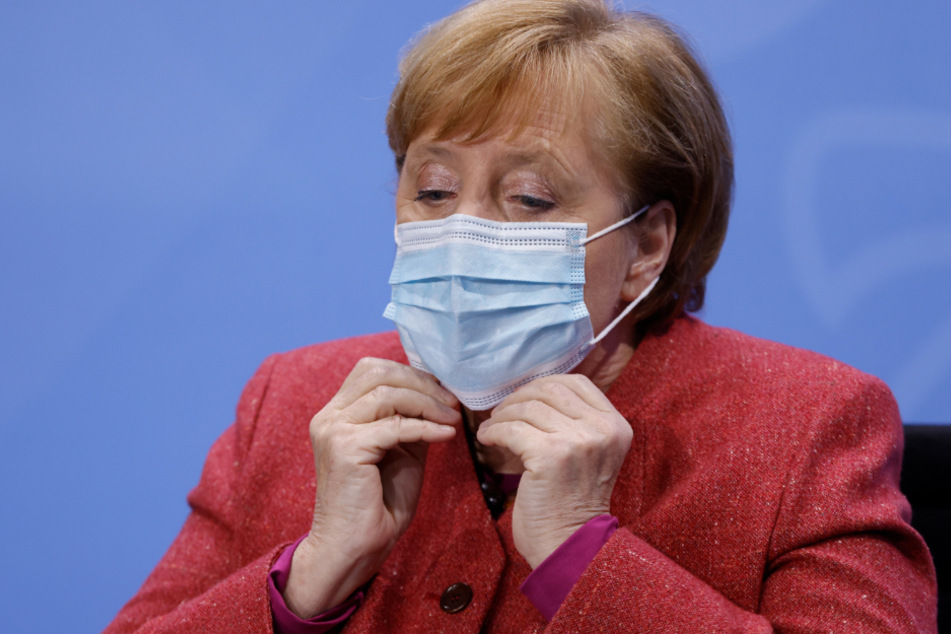 Bundeskanzlerin Angela Merkel setzt sich ihre Mund-Nasen-Bedeckung auf, bevor sie nach einer Pressekonferenz einen Saal im Bundeskanzleramt verlässt.