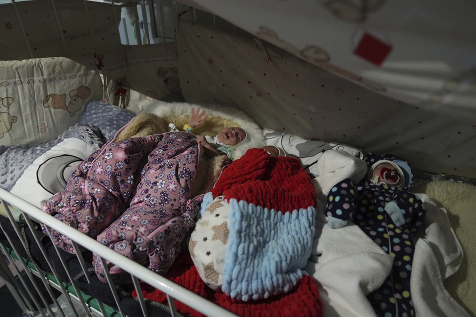 Die drei Frühgeborenen liegen in Decken eingewickelt in einem Krankenhausbett in Mariupol.