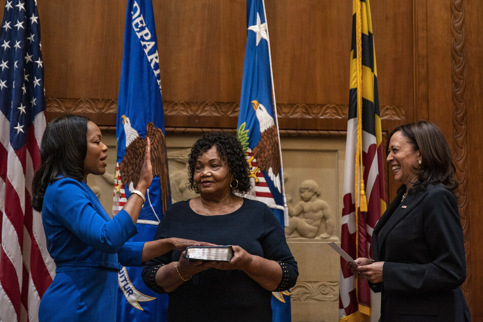 Kristen Clarke (l.) was sworn in by Vice President Kamala Harris (r.). Her mother, Pansy Clarke, held the Bible during the ceremony.