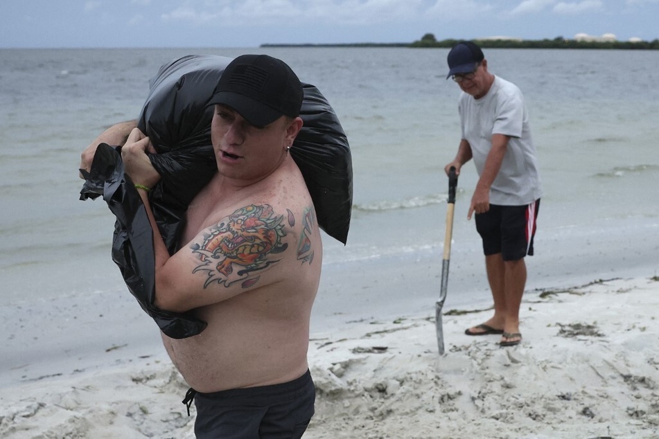 Erwin Martinez and Alfonso Rojas fill sandbags in advance of the arrival of Hurricane Ian on a beach near Tampa, Florida.