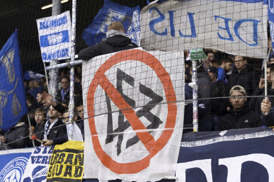 Darmstadt-Fans zeigen ein Transparent , auf dem das DFB-Logo durchgestrichen ist.