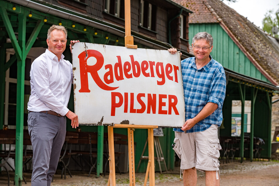 Brauerei-Chef Olaf Plaumann (53, l.) übergibt an "Hofewiese"-Wirt Holger Zastrow (53) das historische Werbeschild.