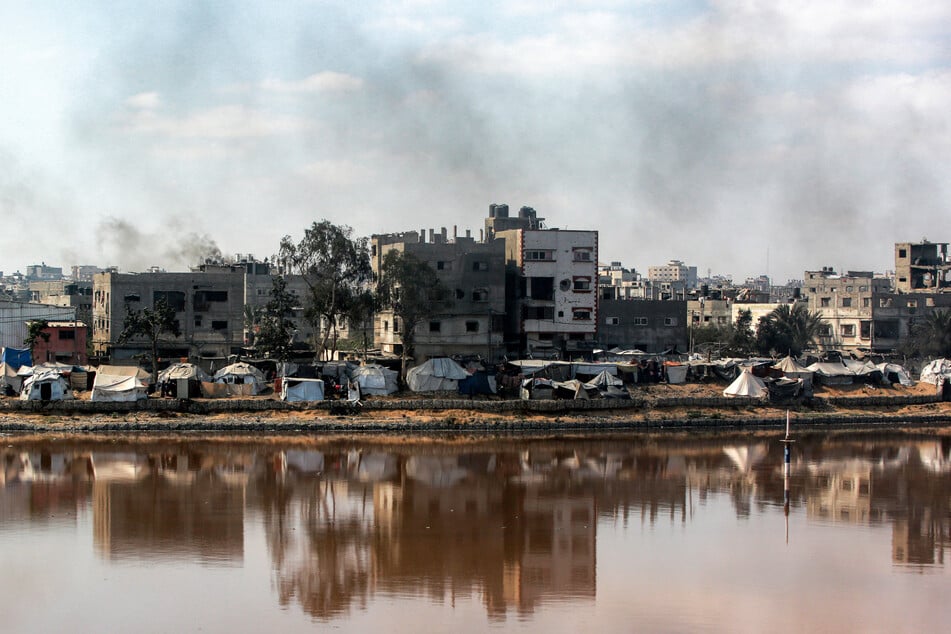 Encampments sheltering displaced Palestinians are pitched near the Sheikh Radwan wastewater collection pond, which is nearing its filling capacity, in Gaza City on July 14, 2025.