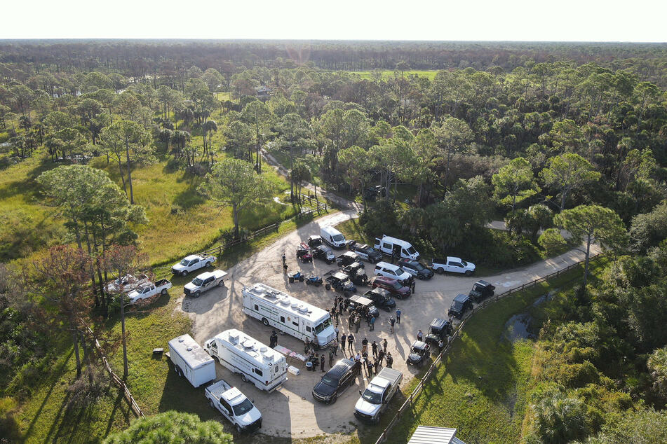 Officers debriefed during the search operation at the Carlton Reservation in South Florida. The vast area and damp terrain makes it difficult to locate the fugitive.