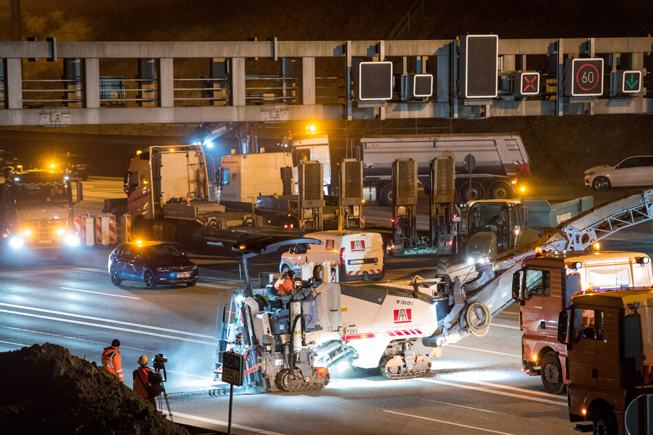 Baufahrzeuge fahren auf der gesperrten Autobahn A7.