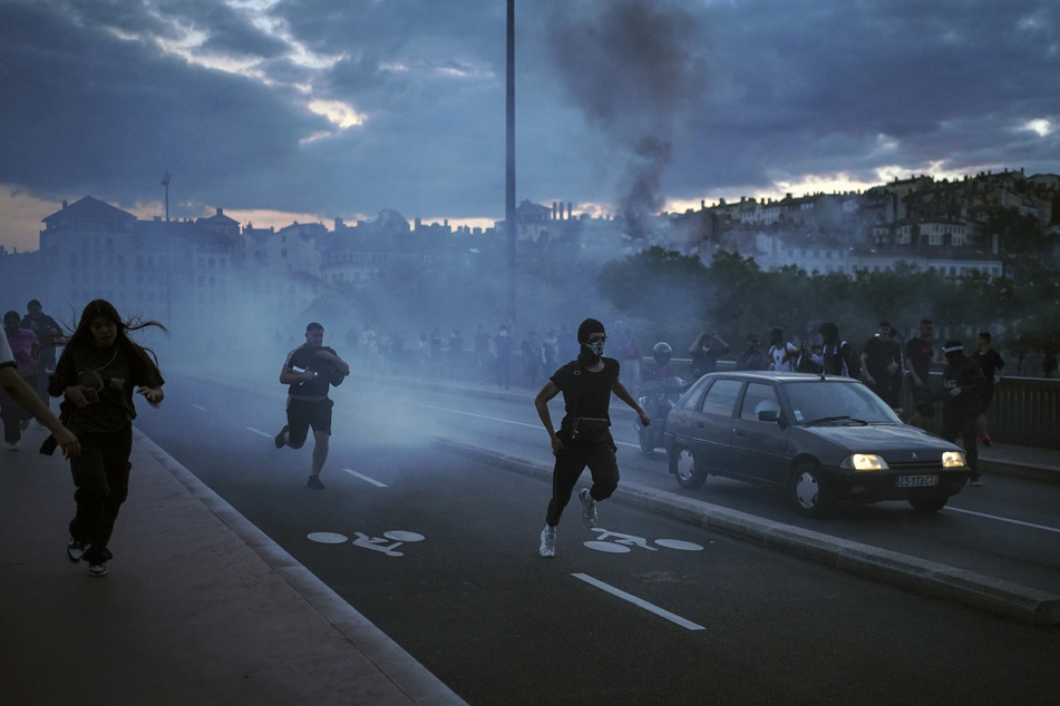 Auch in Lyon kam es zu Ausschreitungen. Menschen fliehen nach einem Zusammenstoß mit Polizisten.