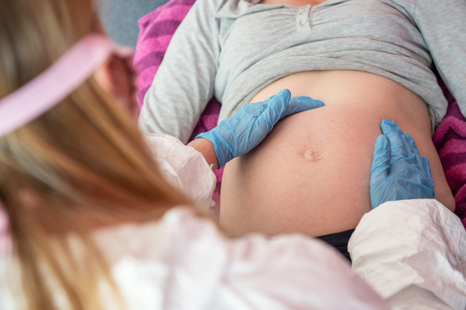 Eine Hebamme untersucht eine schwangere Frau. Der erste Lockdown führte laut der Geburtenstatistik nicht zu mehr Babys in Deutschland.