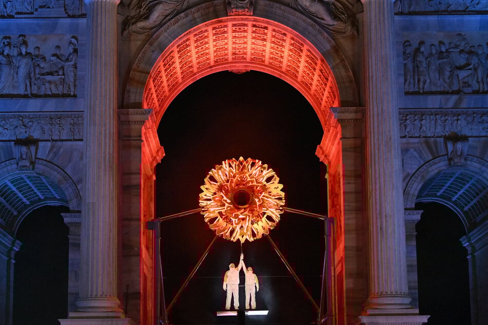 Alberto Tomba (59) und Deborah Compagnoni (55) entzünden bei der Eröffnungsfeier das olympischen Feuer.