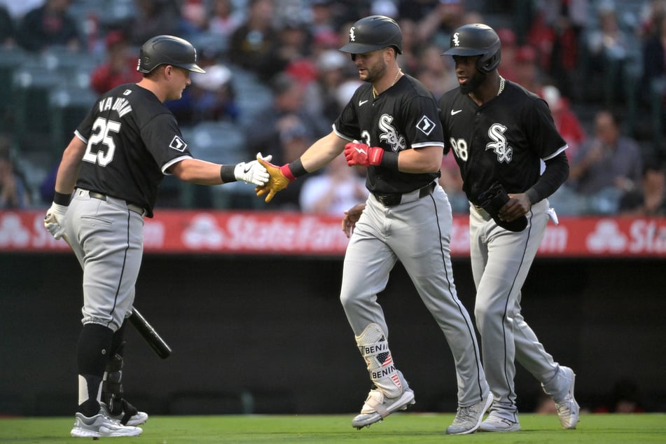 Chicago White Sox first baseman Andrew Vaughn congratulates left fielder Andrew Benintendi as he crosses the plate after hitting a two-run home run in the first inning, scoring center fielder Luis Robert Jr., against the Los Angeles Angels.