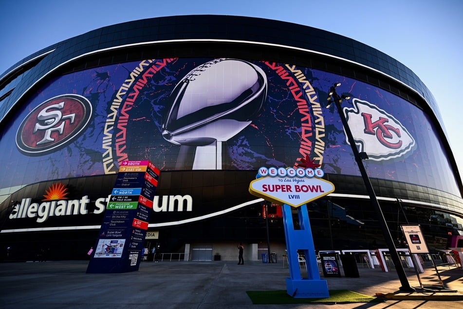A "Welcome to the Las Vegas Super Bowl LVIII" sign stands outside of Allegiant Stadium wrapped with the logos of the Kansas City Chiefs and San Francisco 49ers with the NFL Lombardi Trophy on February 11, 2024.
