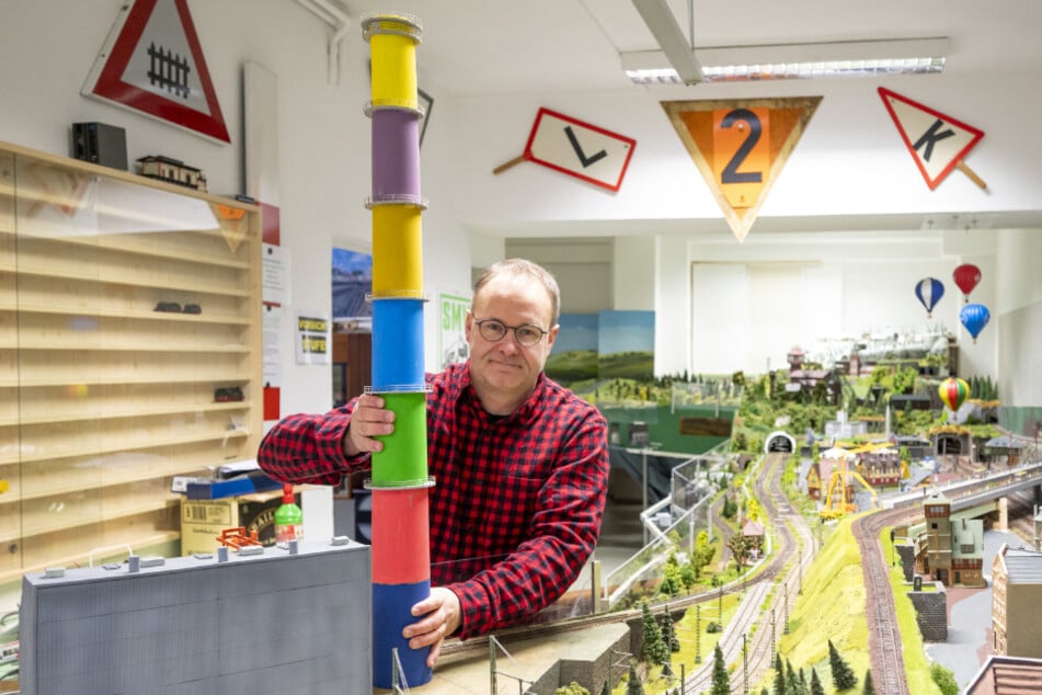 Vereins-Chef Tino Krauß (51) mit der nachgebauten bunten Esse, die neuerdings die Modellbahn-Anlage schmückt.