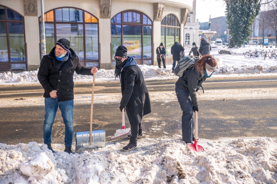 Markus Saalbach (l), Betreiber des Leipziger Dunkelrestaurants "Mondschein" an der Kreuzung am Goerdelerring. Leipzigs Restaurant- und Kneipenbetreiber hatten sich am Mittwoch zusammengetan, um die Messestadt von Schnee und Eis zu befreien.