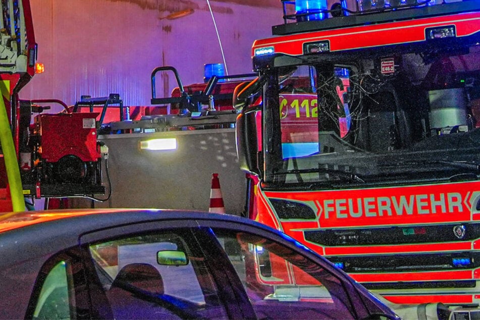 Das brennende Material wird außerhalb der Lagerhalle von der Feuerwehr gelöscht. (Symbolfoto)