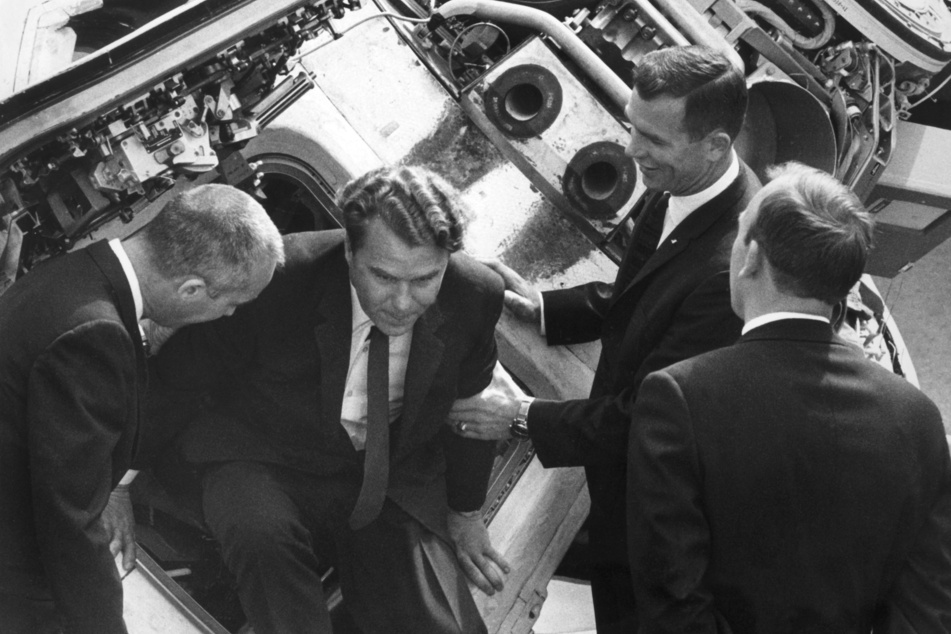 Wladimir Schatalow (M) klettert nach einer Besichtigung aus der Apollo 8 Raumkapsel, links hilft der amerikanische Astronaut James McDivitt. Aufgenommen während der Luftfahrtschau in Le Bourge am 2. Juni 1969.