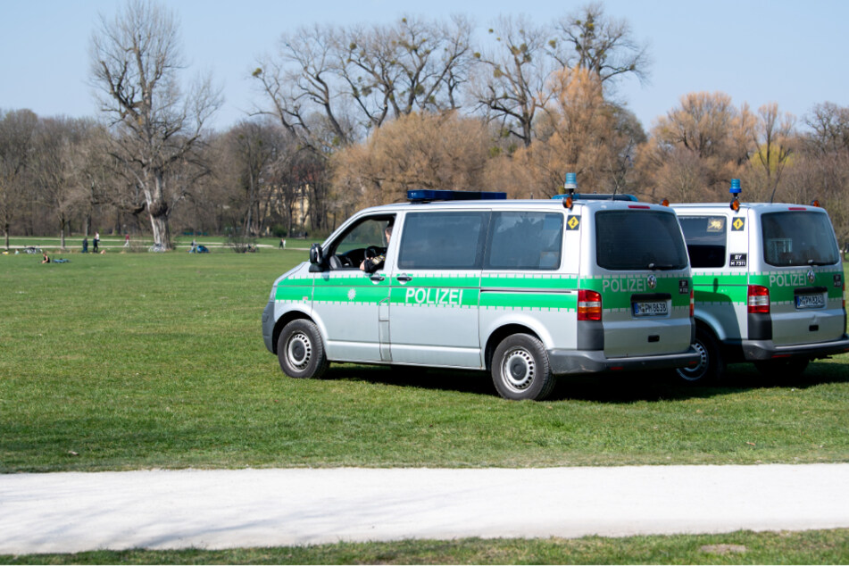 Zwei Polizeifahrzeuge stehen im Englischen Garten. (Symbolbild)