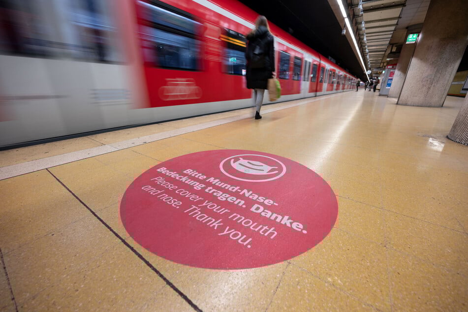 Ein Aufkleber weist in einer S-Bahn Haltestelle auf das Tragen einer Mund-Nasen-Bedeckung hin.