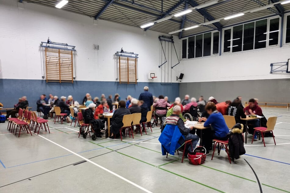 In der Turnhalle des Gymnasiums Einsiedel haben sich einige Menschen eingefunden.