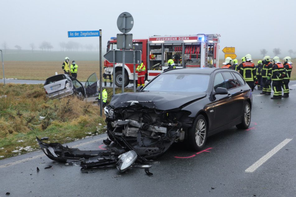 Der deutlich vom Unfall gekennzeichnete schwarze BMW. Im Hintergrund liegt der Mercedes im Straßengraben.