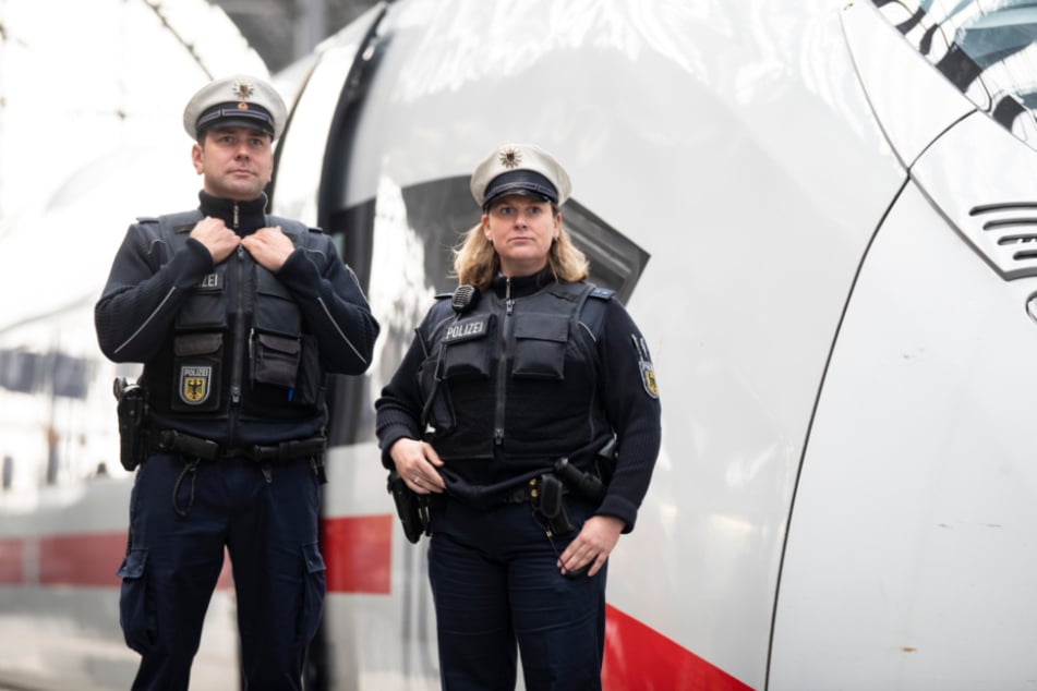 Zwei Beamte der Bundespolizei stehen vor einem Zug. (Symbolbild)