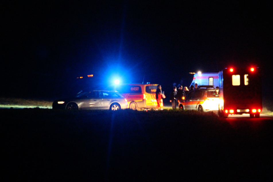Mann liegt auf einem Feldweg neben seinem Auto und stirbt