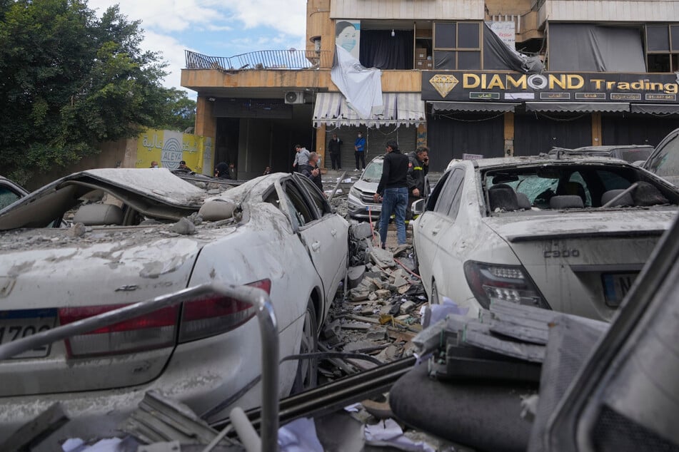 Menschen stehen am Ort eines israelischen Luftangriffs, bei dem ein Wohnhaus in Dahiyeh, einem südlichen Vorort von Beirut, Libanon, getroffen worden war.