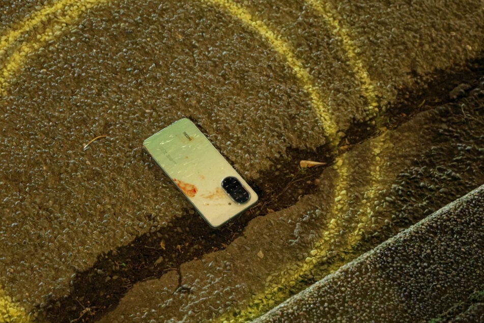 Das Handy des Unfallopfers lag nach dem Unfall blutverschmiert am Boden.