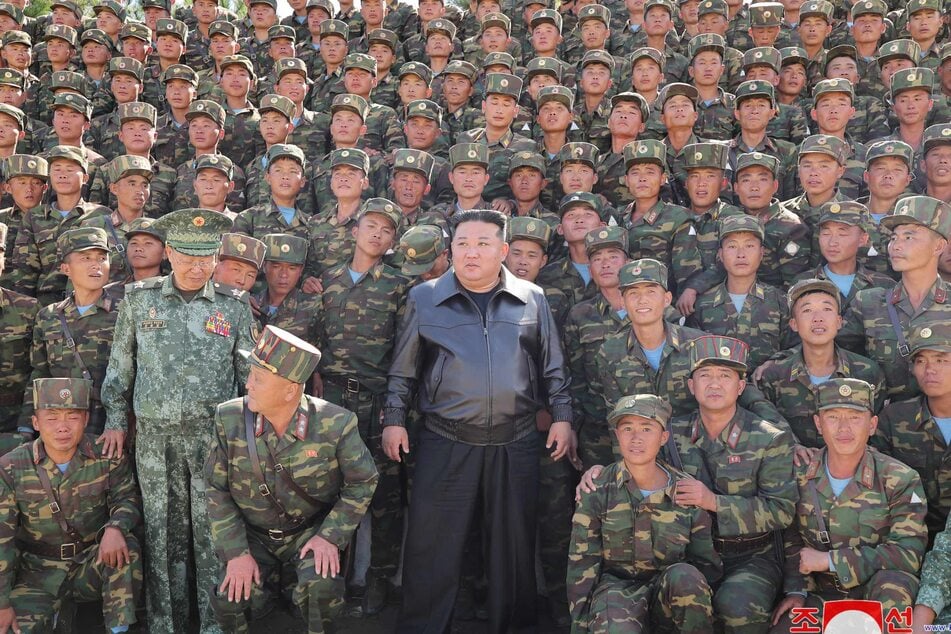 This picture taken on October 2, 2024 and released from North Korea's official Korean Central News Agency (KCNA) via KNS on October 4, 2024 shows North Korea's leader Kim Jong Un (c.) posing with troops during an inspection at a training base of the Korean People's Army's special operations forces in the western region, at an undisclosed location in North Korea.