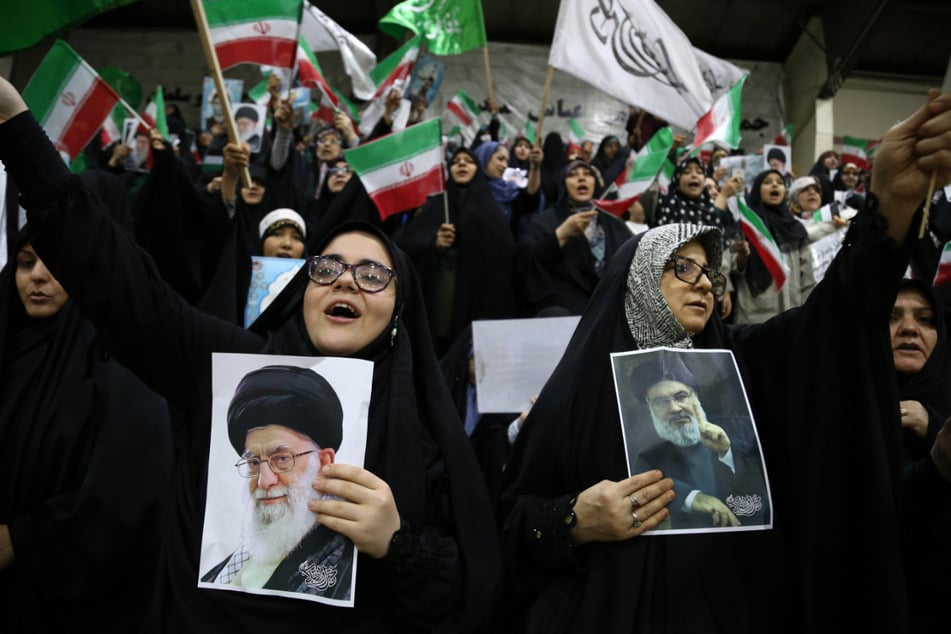 Eine iranische Frau hält ein Porträt von Hassan Nasrallah während einer Pro-Hijab- und Pro-Regierungs-Versammlung in der Teheraner Innenstadt hoch.
