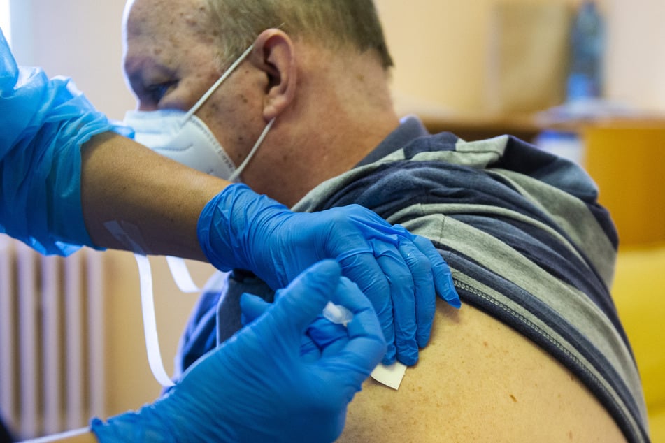 Ein Mitarbeiter des Gesundheitswesens verabreicht einem Mann in der Slowakei eine Impfung mit dem russischen Impfstoff Sputnik V.