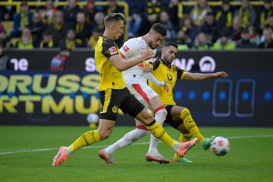 Leipzigs Romulo (M.) wird von Nico Schlotterbeck (l.) und Yan Couto in die Zange genommen.