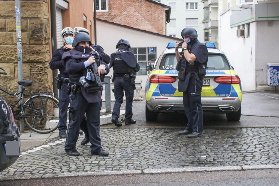 Schwer bewaffnete Polizisten stehen an der Immenhoferstraße in Stuttgart. Ein Mann hatte sich mit einem Messer in seiner Wohnung verschanzt.