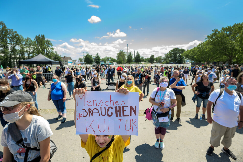 Maja (11, M) hält einen Zettel mit der Aufschrift "Menschen geBrauchen Kultur" auf einer Kundgebung der Veranstaltungsbranche hoch.