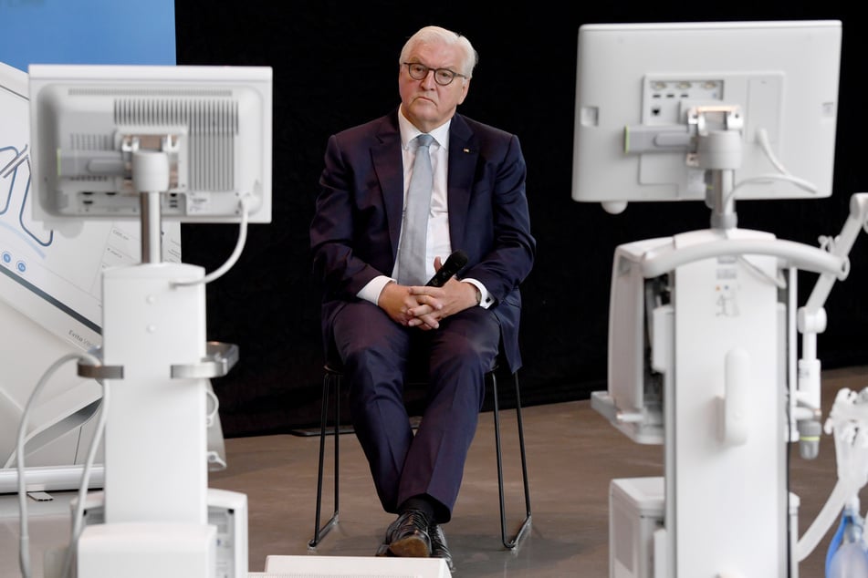 Bundespräsident Frank-Walter Steinmeier sitzt bei einem Besuch des Werkes des Medizintechnik-Herstellers Dräger zwischen Intensiv-Beatmungsgeräten.
