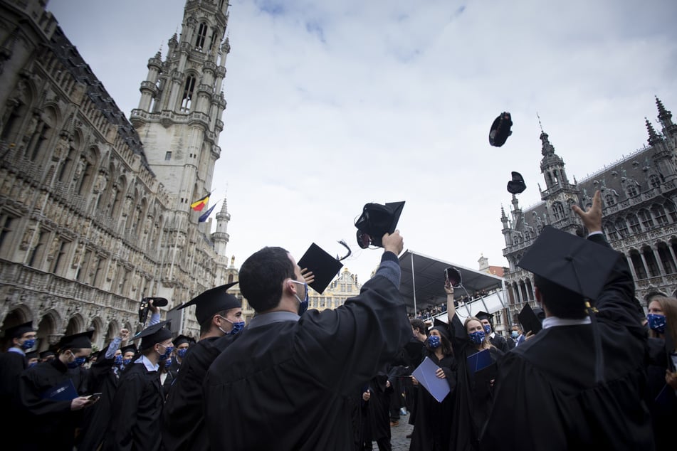 Belgien, Brüssel: Ingenieursabsolventen der "Université Libre de Bruxelles" werfen bei ihrer Abschlussfeier ihre Doktorhüte in die Luft. Aufgrund der Corona-Pandemie wurden wichtige Prüfungen vom Juni auf Folgemonate verschoben.