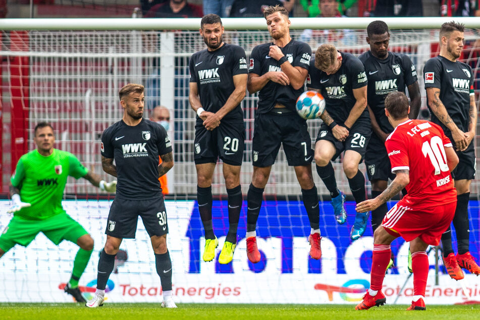 Unions Max Kruse (33, im roten Trikot) bleibt an der Augsburger Mauer hängen. Der FC Augsburg geriet in Zinglers Kritik.